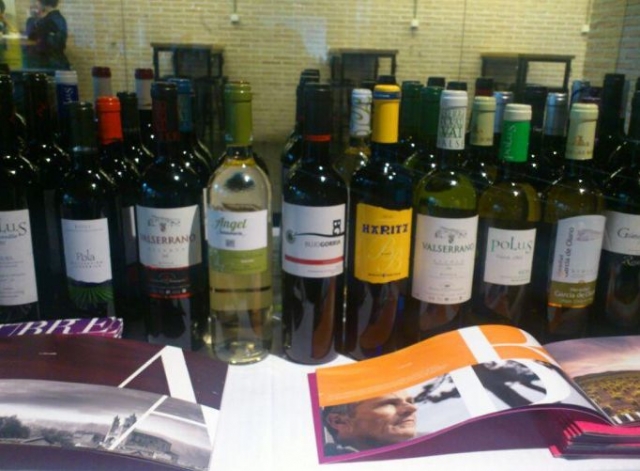 botellas de vino junto a unos libros informativos
